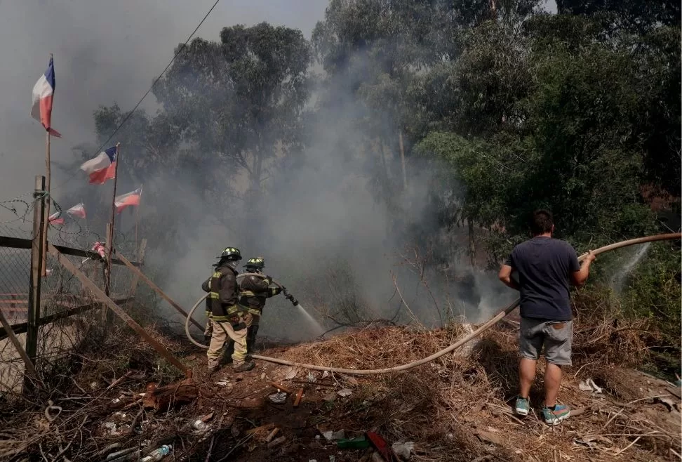 Personas combaten el fuego junto a bomberos en la zona de Las Palmas, durante los incendios forestales que afectan a Viña del Mar Región de Valparaiso (Chile).